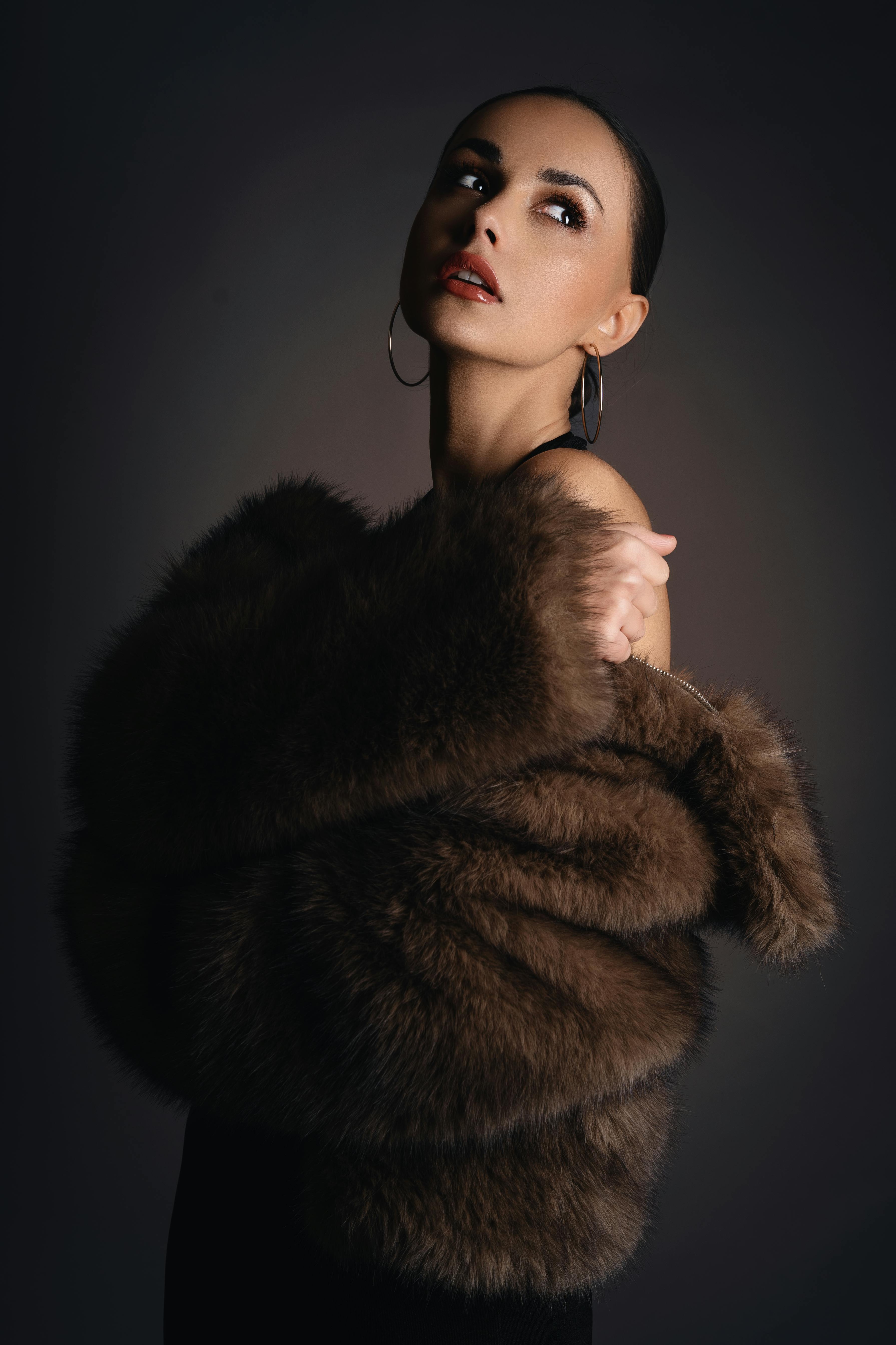 Gratis Retrato de moda sofisticado que presenta una modelo femenina con un lujoso abrigo de piel. Foto de stock