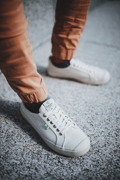 White Low Top Sneakers And Brown Pants