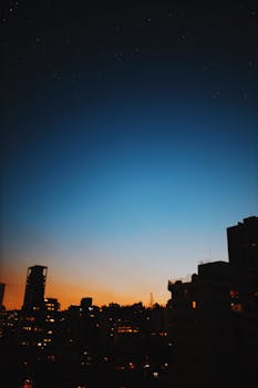 暮色地平线下，城市景观的剪影与星空交相辉映