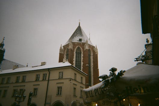 Snow blankets the historic streets and architecture of Krakow, Poland.