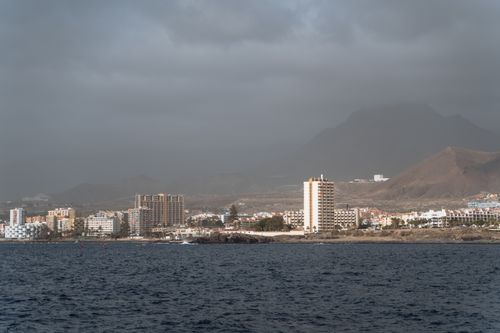 Free Scenic view of Los Cristianos with mountainous backdrop and coastal cityscape, Tenerife. Stock Photo