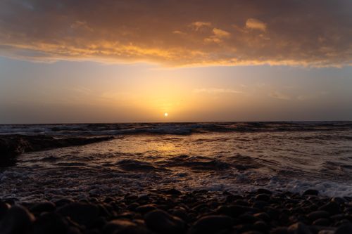 Free Breathtaking sunset over tranquil waters on a Canary Islands beach, perfect for travel inspiration. Stock Photo