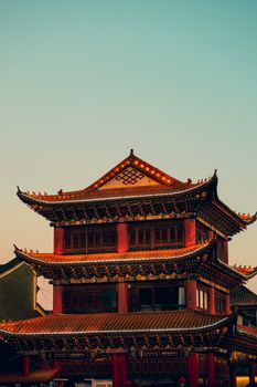 A beautifully detailed traditional Chinese pagoda bathed in the warm glow of sunset.