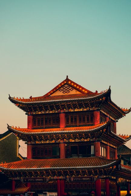 A beautifully detailed traditional Chinese pagoda bathed in the warm glow of sunset.