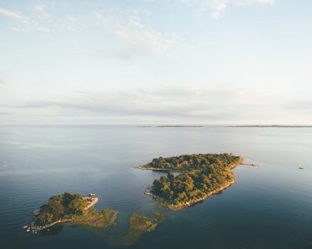 日落时分，平静水域环绕着宁静岛屿的鸟瞰风景