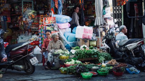 Free Authentic scene of a bustling Vietnamese street market with local vendors and fresh produce. Stock Photo
