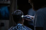 理发师在理发店用电推子精确地理发