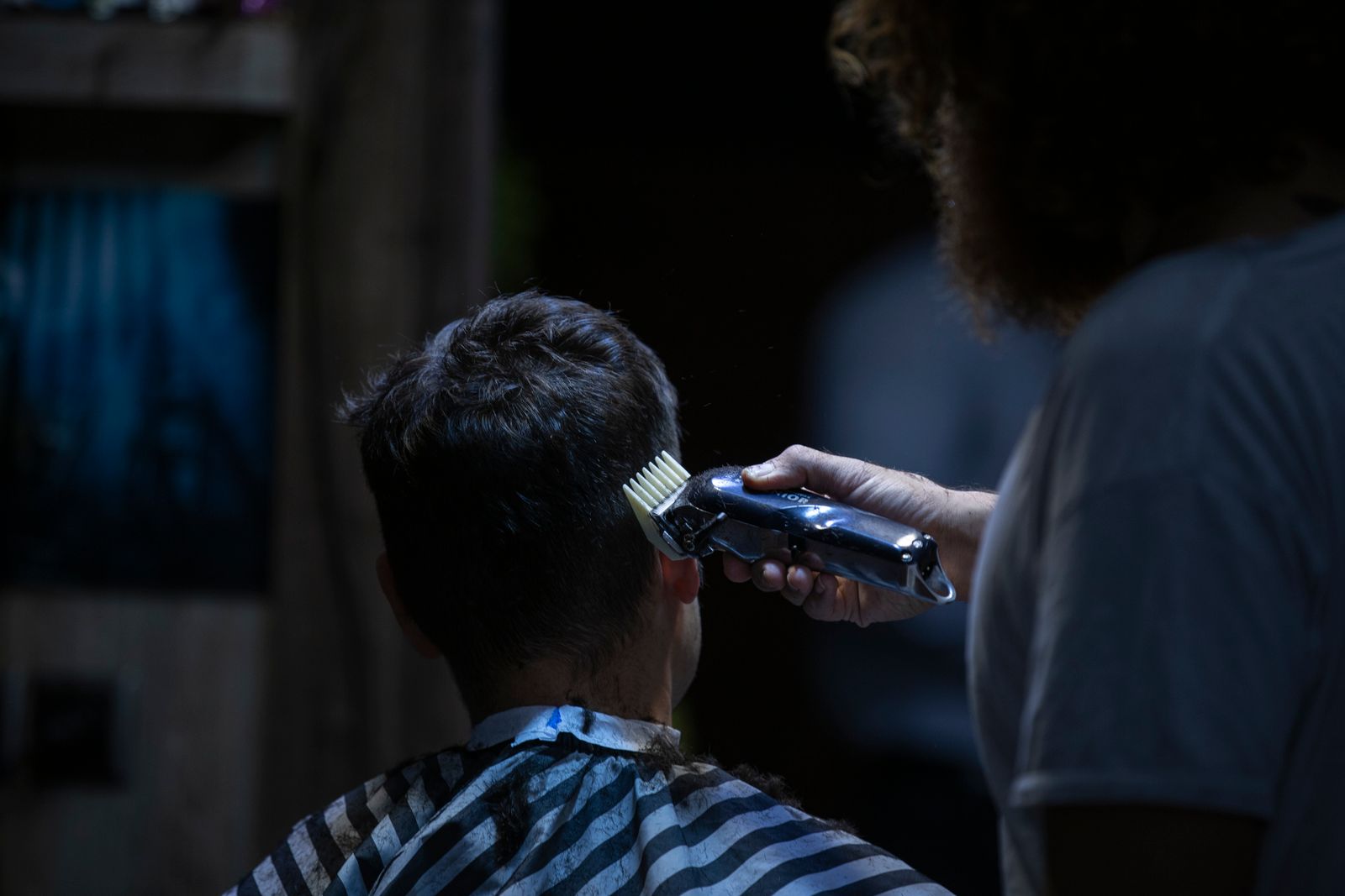 Barbero haciendo un corte con máquina