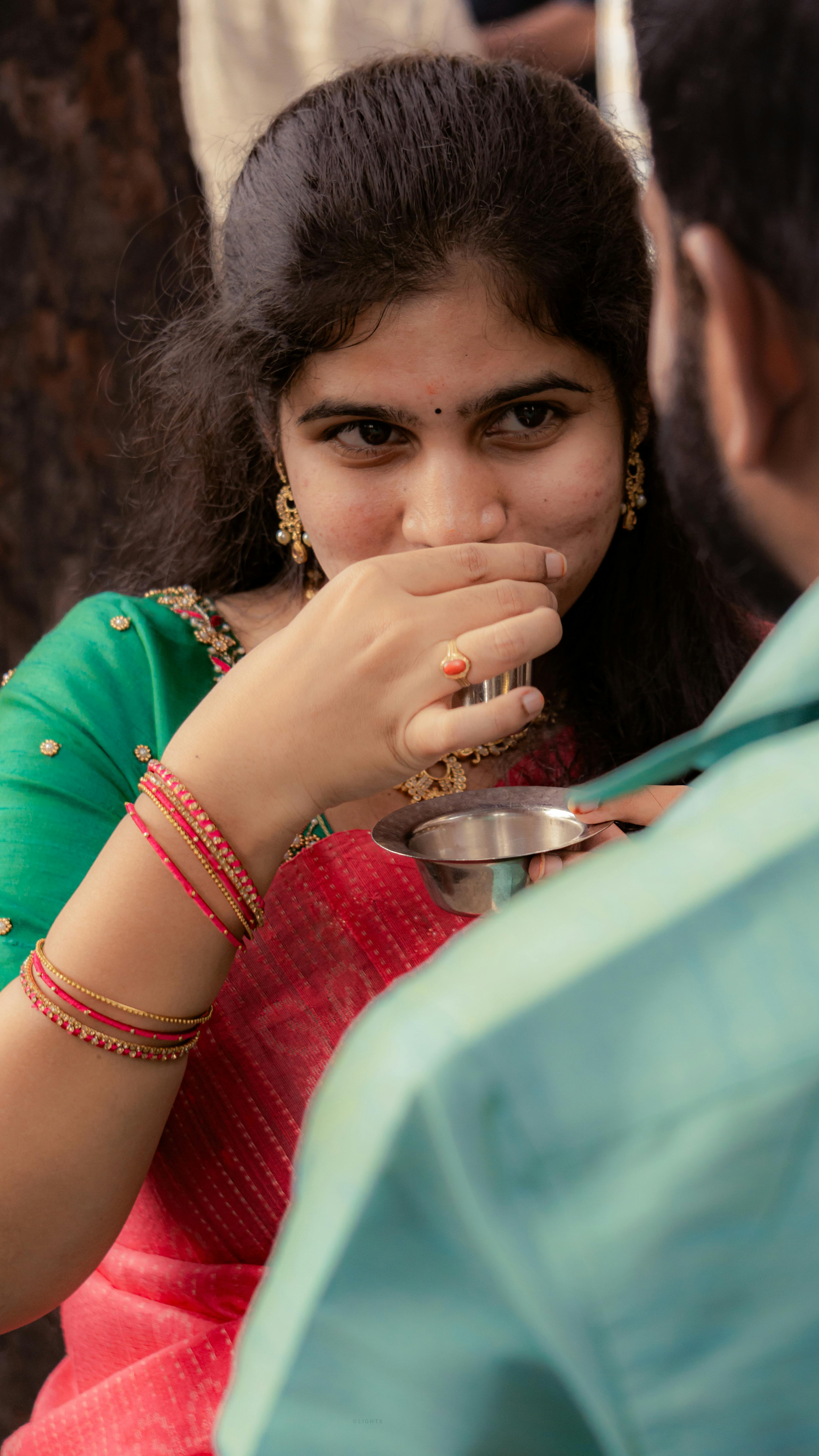 A woman in traditional attire enjoying a festive moment, sharing cultural joy.