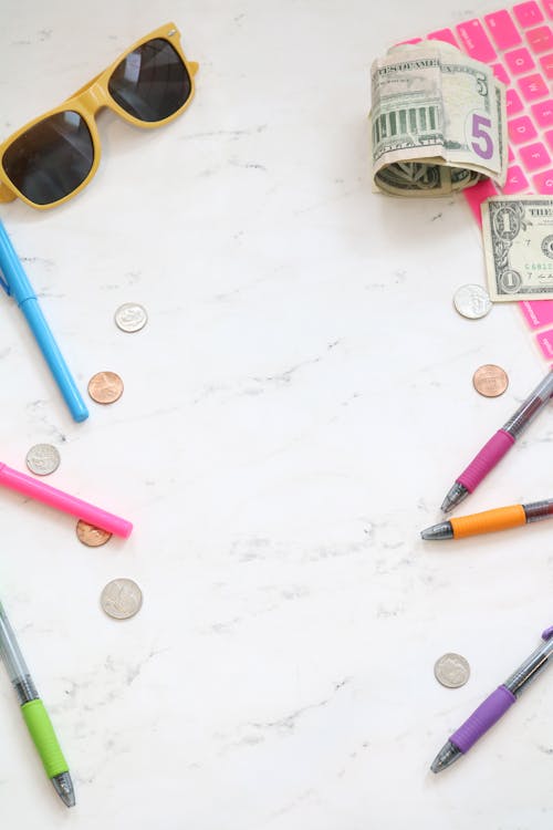 Free Cash, Sunglasses and Pens on Marble Surface Stock Photo