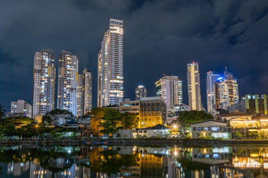 Illuminated skyscrapers reflected on the water, showcasing a vibrant city nightlife.