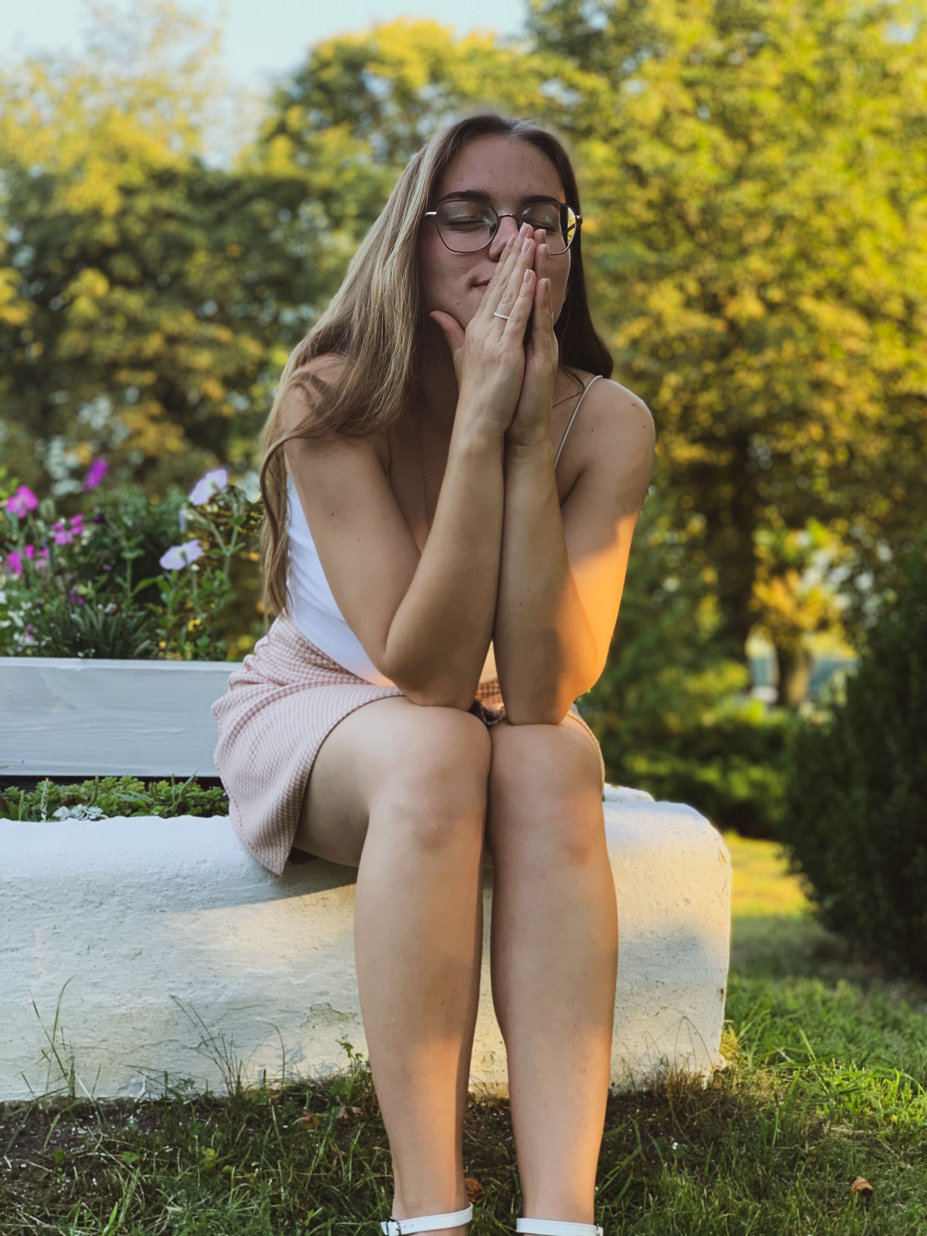 Young Woman Sitting Outdoors in Serene Park · Free Stock Photo