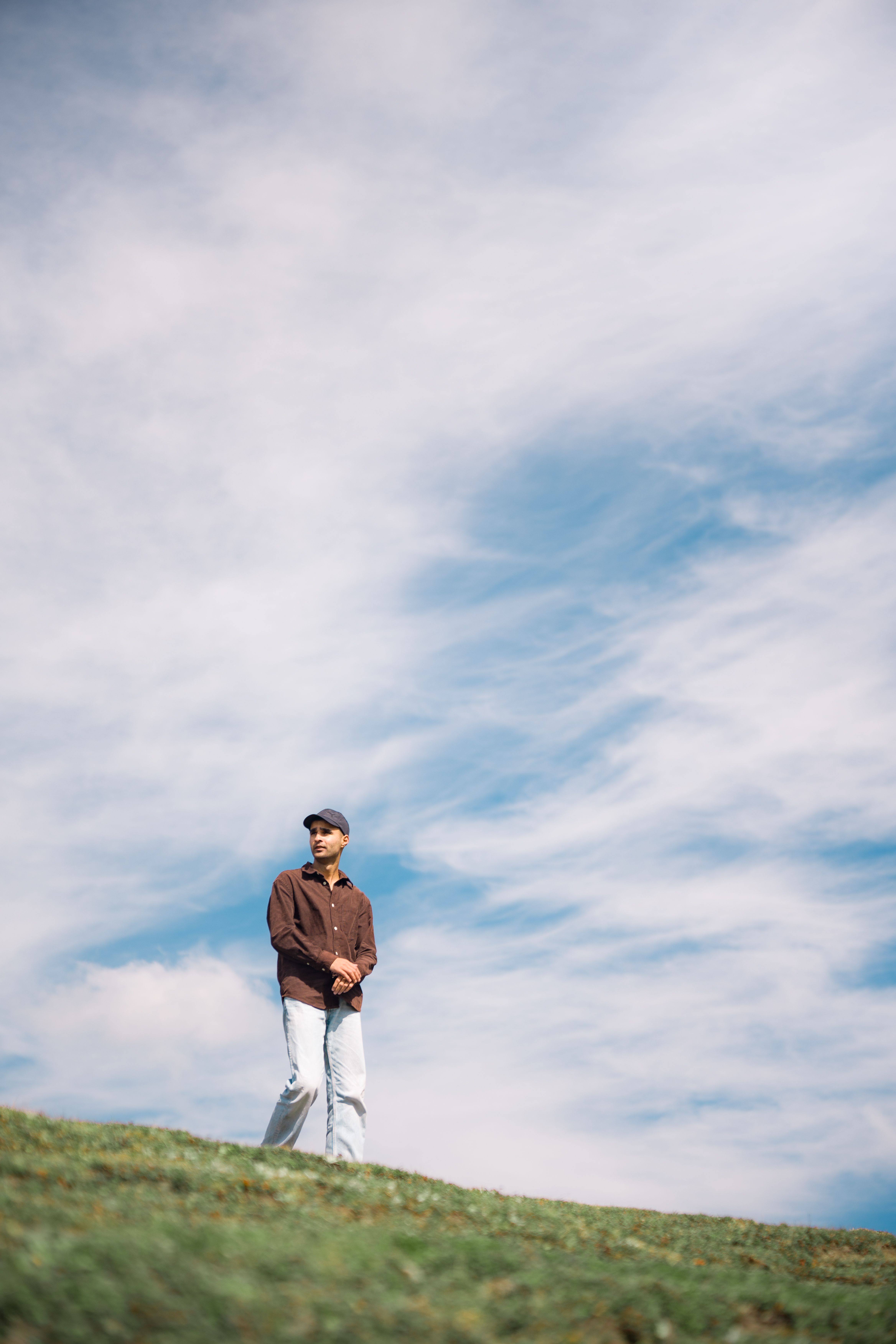 Man Standing on a Hill Under Blue Sky · Free Stock Photo
