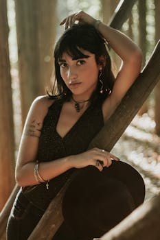 一位优雅的女人戴着黑色帽子，在宁静的森林中摆出姿势