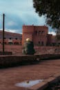 Person Sitting Near Historic Architecture at Dusk