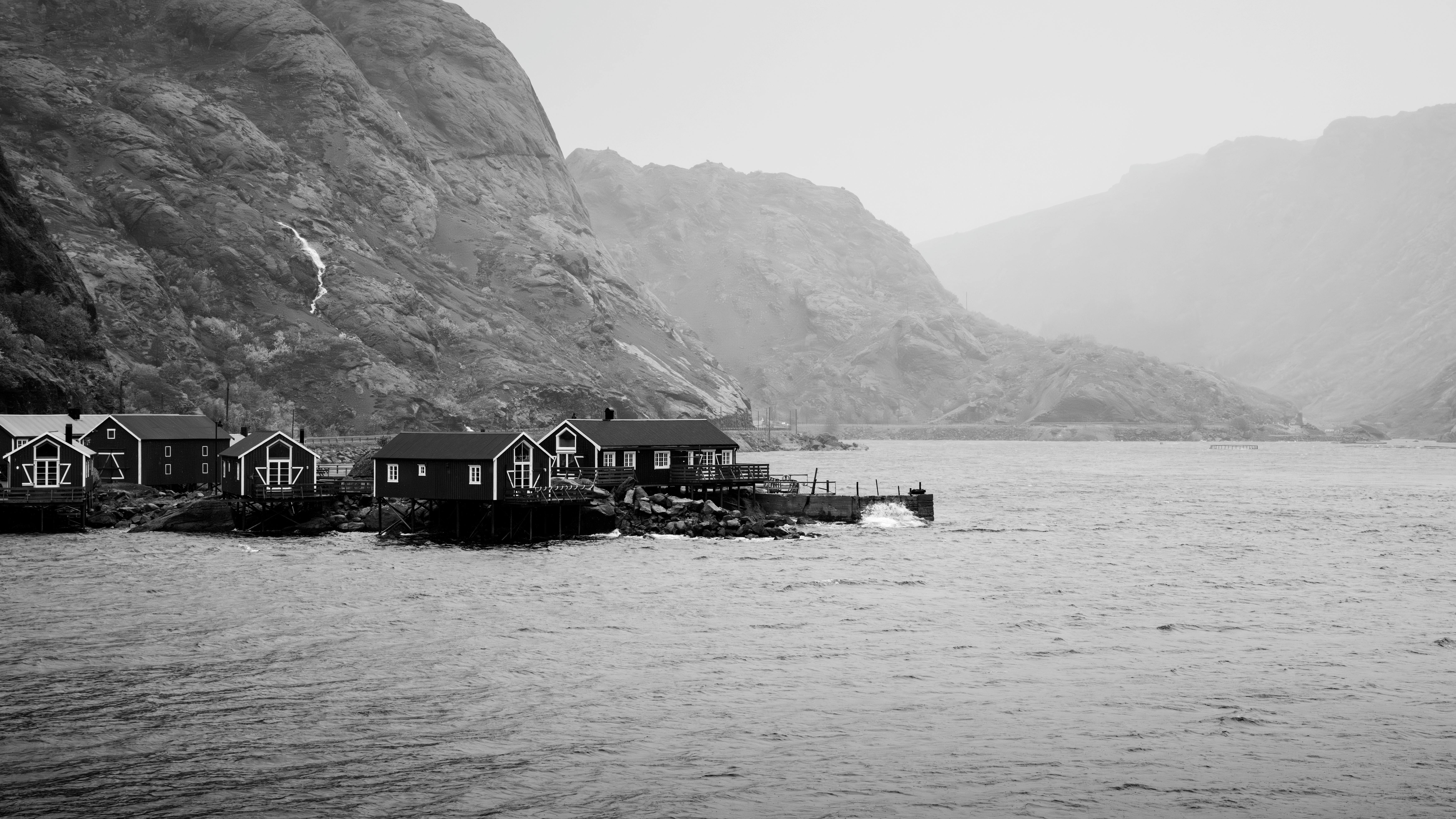 Monochrome image of traditional Norwegian coastal houses by the sea.