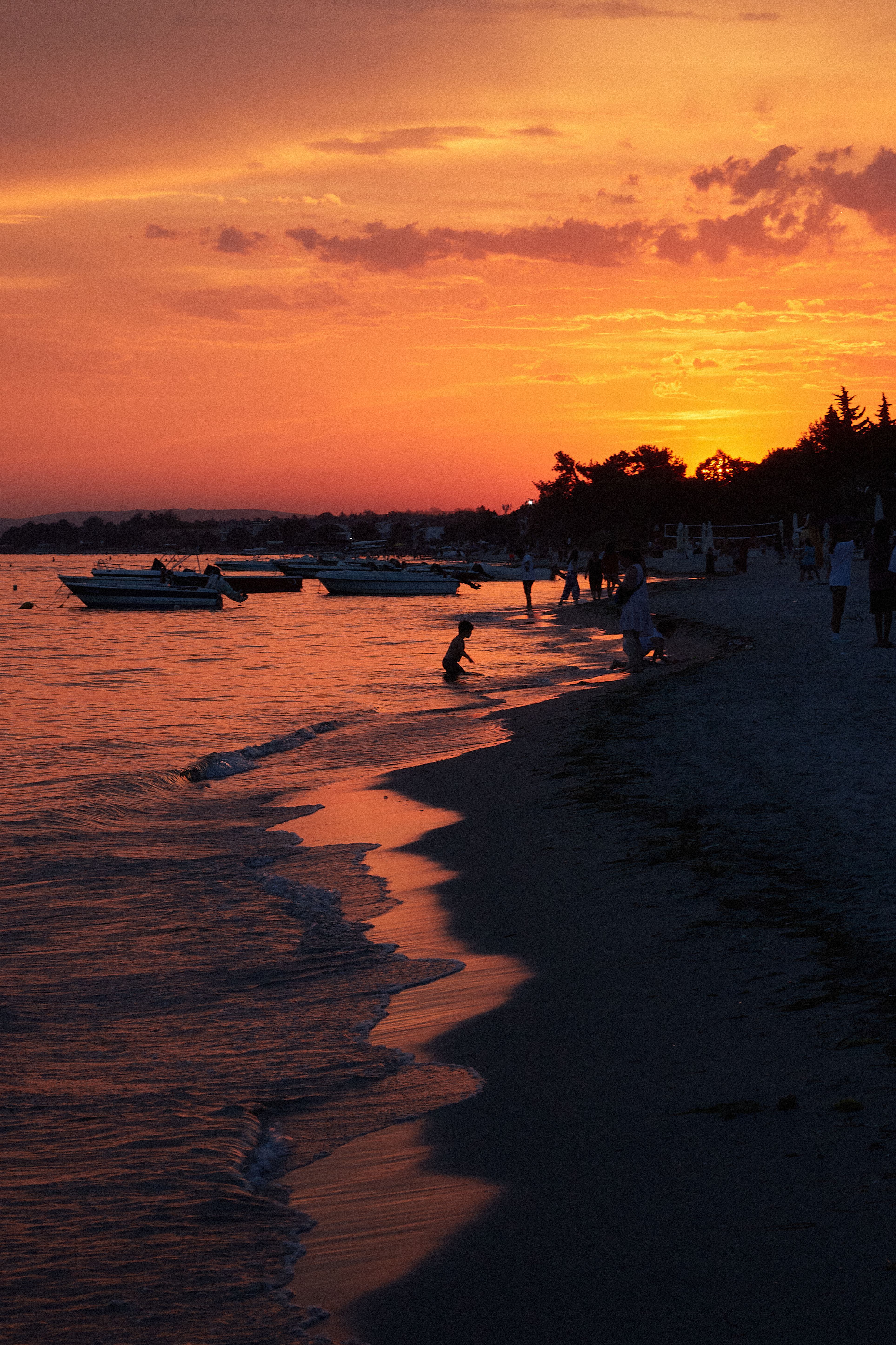 Stunning Beach Sunset with Silhouettes and Boats · Free Stock Photo