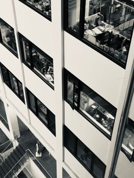 High-angle view of a bustling office with visible desks and employees.