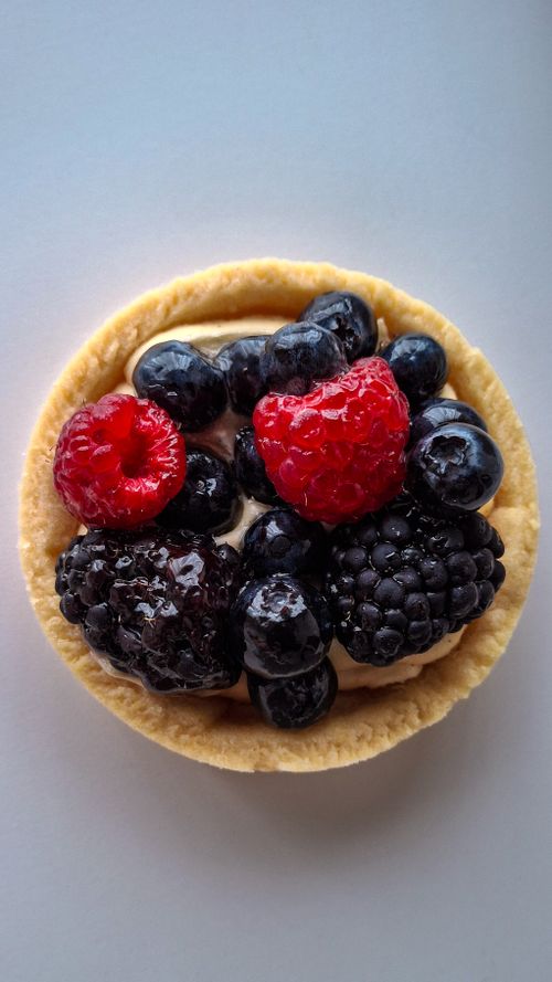 Free Artisanal tart featuring fresh raspberries, blackberries, and blueberries. Stock Photo