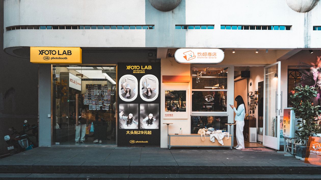 Modern Photo Lab Storefront with Customer Outdoors · Free Stock Photo
