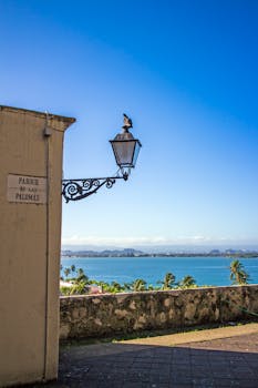 Scenic seaside view from Parque de las Palomas with a lamp and distant mountains.
