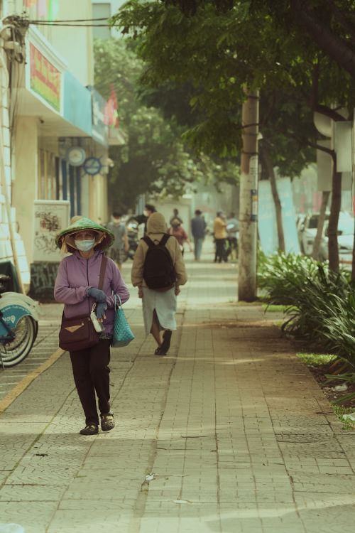 Free A busy city street with people walking and greenery, reflecting urban life. Stock Photo