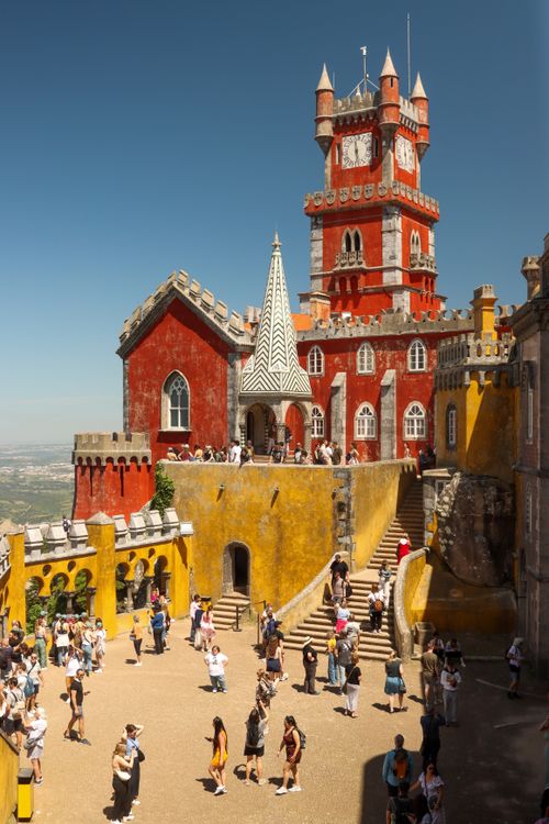 Free Vibrant National Palace of Pena in Sintra, Portugal, with tourists exploring the historic site. Stock Photo