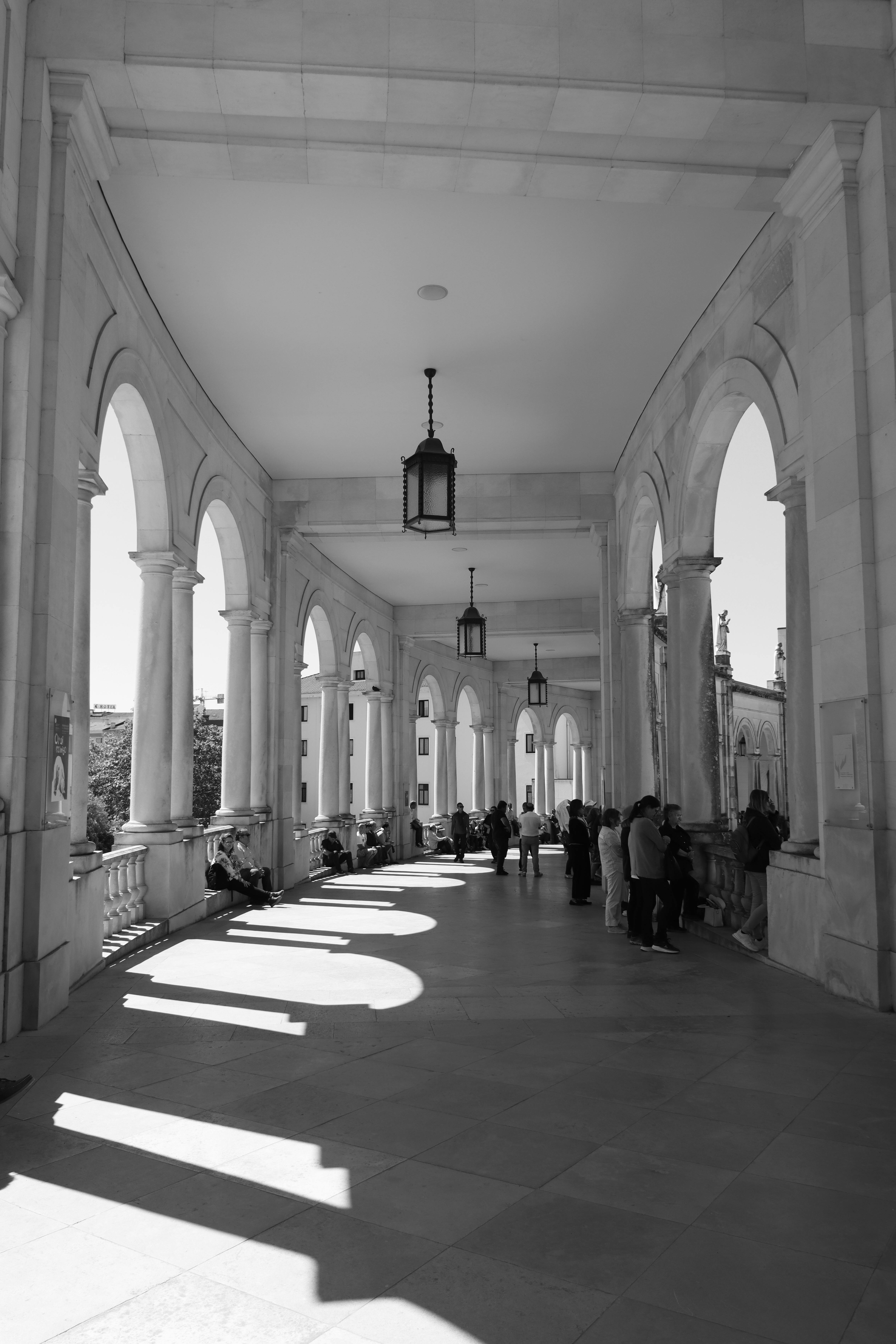 Elegant arched walkway in a Portuguese building, capturing the interplay of light and shadow.