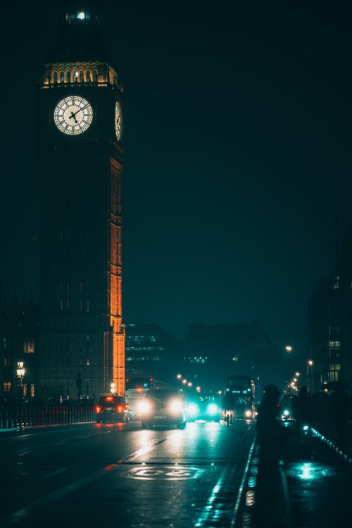 Free Night view of Big Ben in London, lights reflecting on wet streets. Iconic landmark. Stock Photo