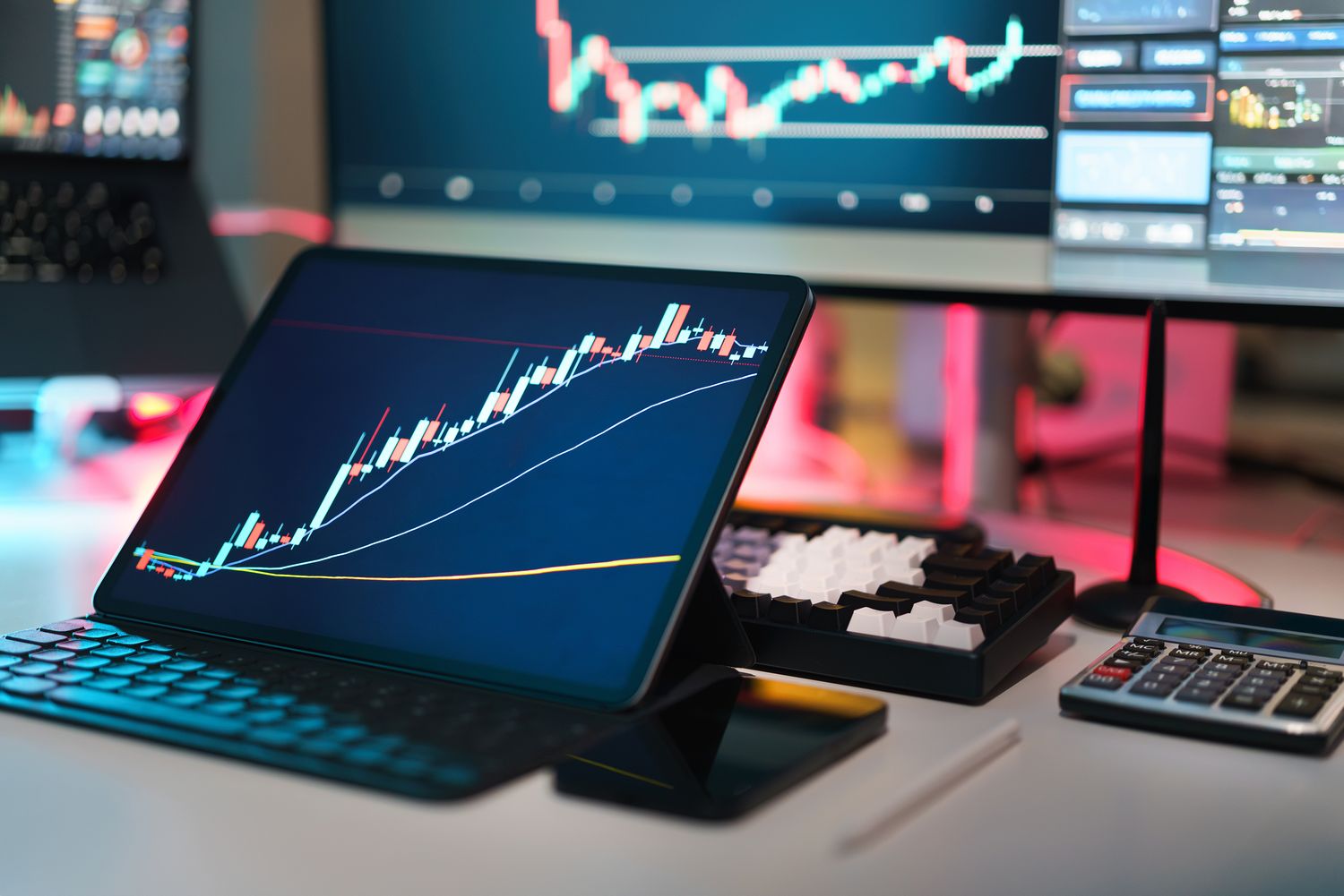 Mesa con varios dispositivos mostrando información de mercado