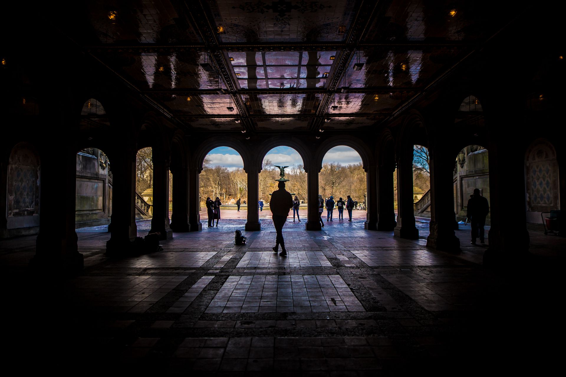 Silhouette of people under Bethesda Terrace arches in Central Park, NYC.