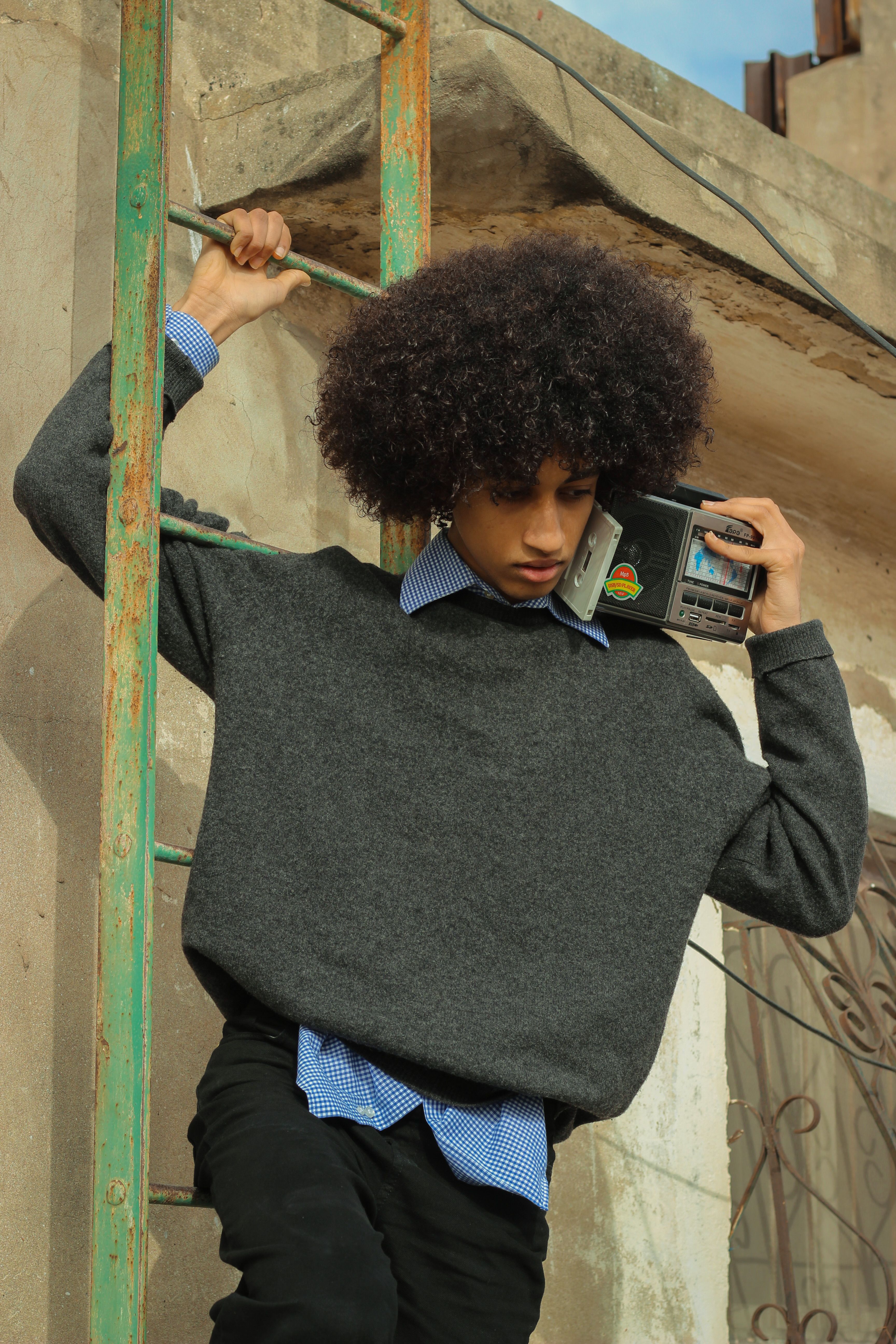Stylish individual with retro radio on a Casablanca rooftop, blending modern and vintage fashion.