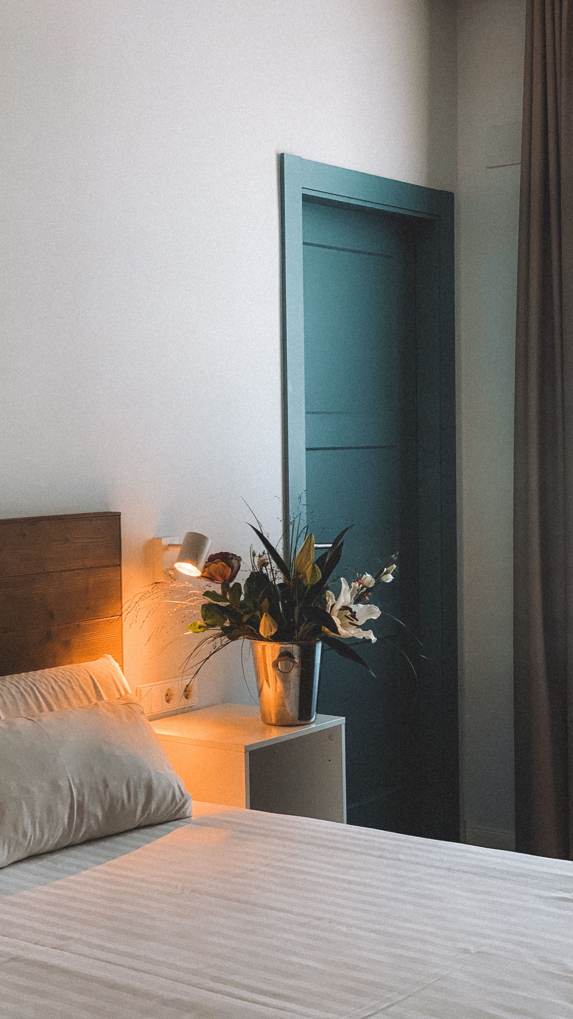 A tranquil bedroom corner with soft lighting and a floral arrangement for a serene ambiance.