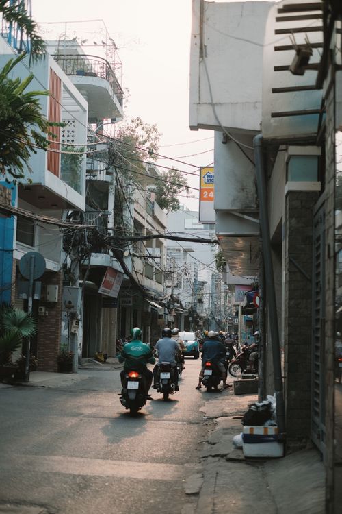 Free A lively street in Ho Chi Minh City with multiple motorcyclists during daytime. Stock Photo