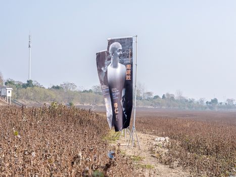 Banners promoting an event stand in a dry rural landscape.