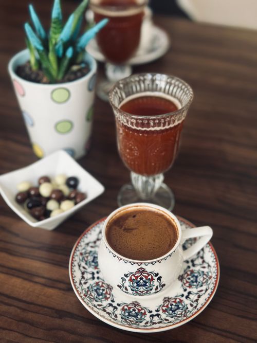 Free Artistic presentation of Turkish coffee in a patterned cup with accompanying glass. Stock Photo