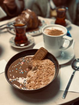 A cozy breakfast setup featuring a chocolate breakfast bowl, coffee, and tea.
