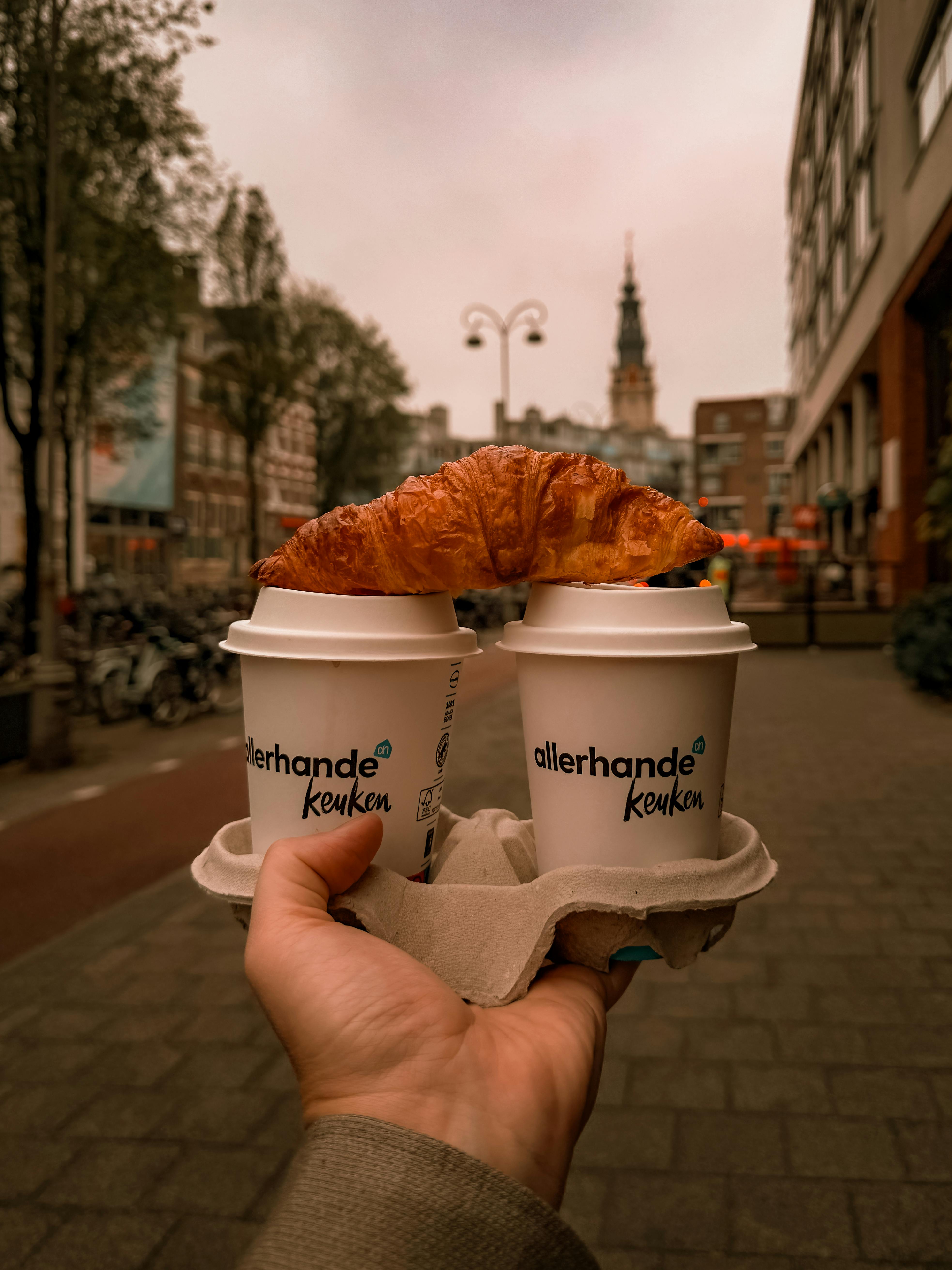 Enjoy a cozy morning with coffee and croissant in Amsterdam's charming streets.