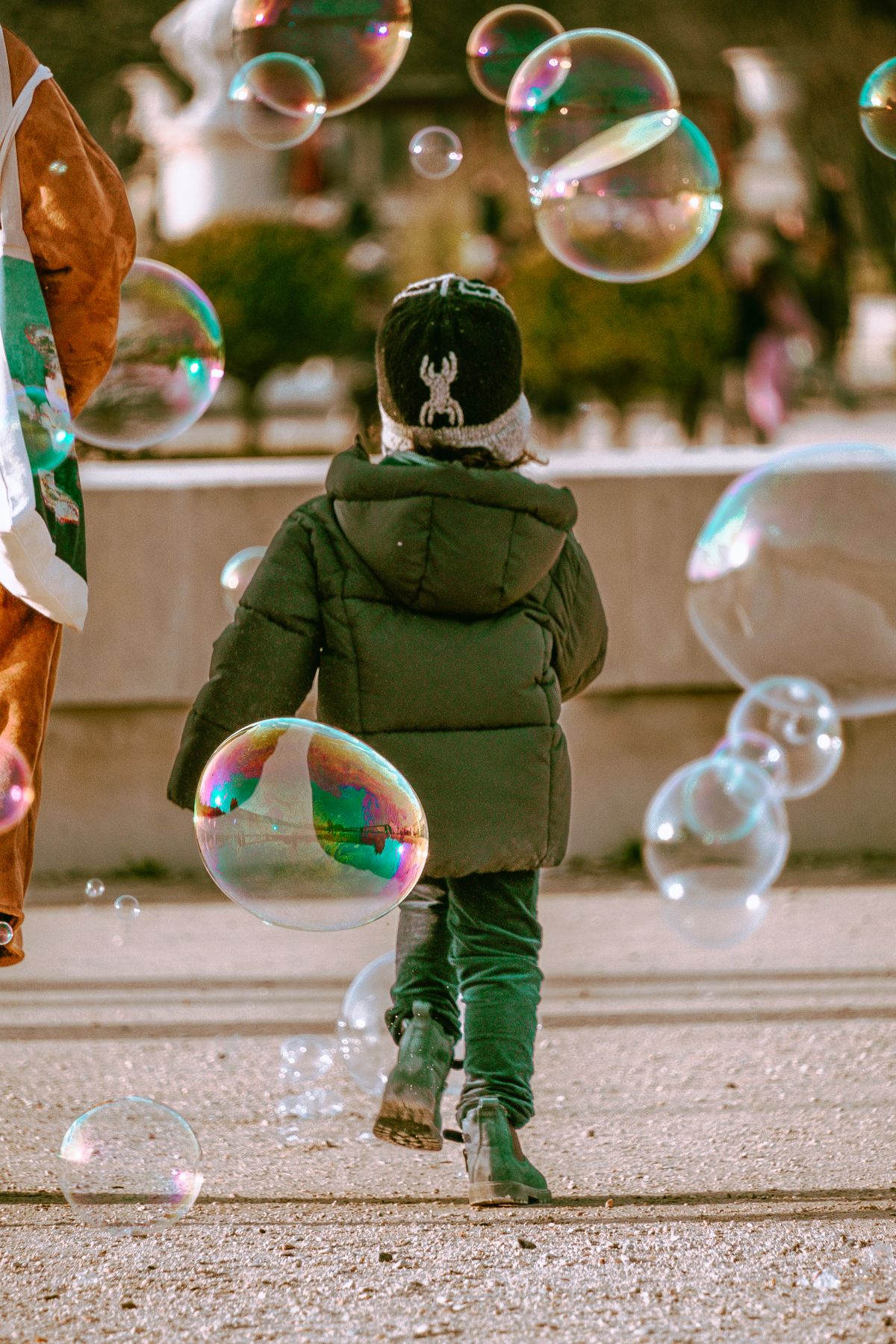 Child playing with bubbles in a park during scavenger hunt games