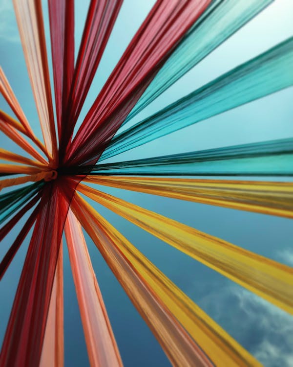 Low Angle Shot Of A Of Multi Colored Textile Attached Together On A Pole 