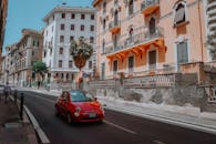 罗马风景秀丽的城市街道上，经典的意大利建筑与红色汽车形成了鲜明的对比