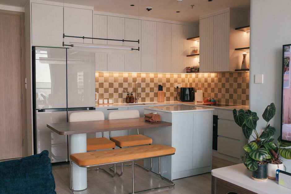 Photo by Huy Phan on Pexels Stylish modern kitchen interior with bench seating, seamless cabinets, and warm lighting.