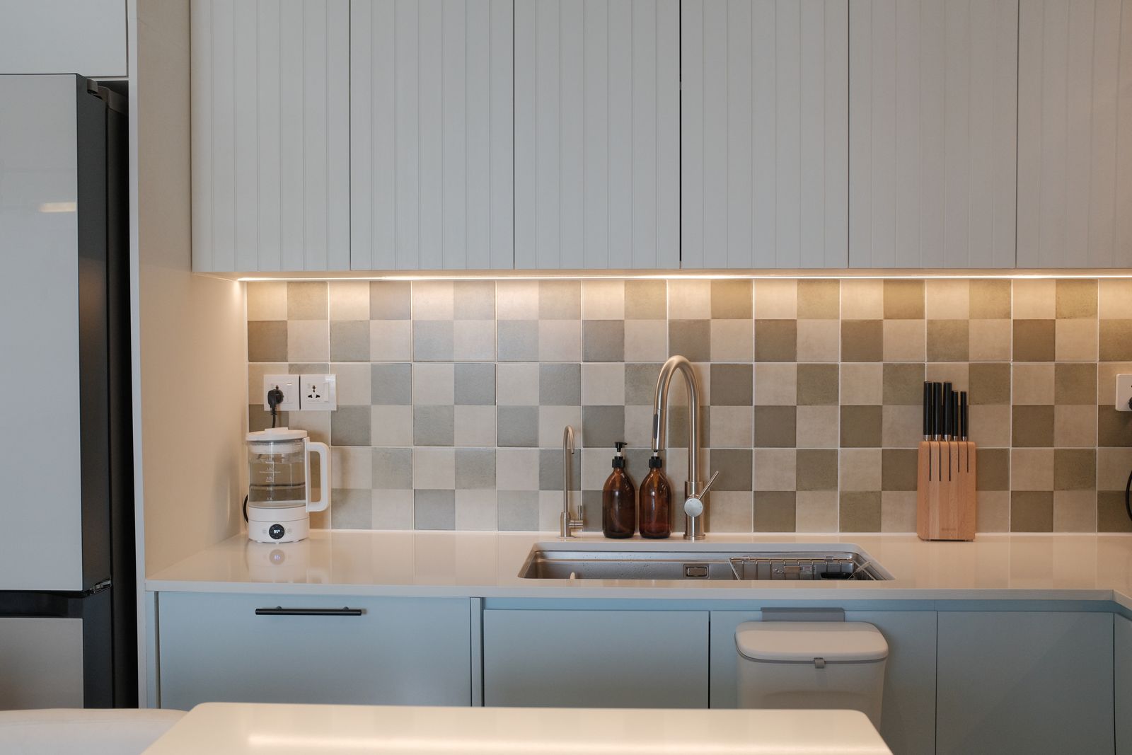 Modern kitchen splashback tiling behind cabinetry and worktops