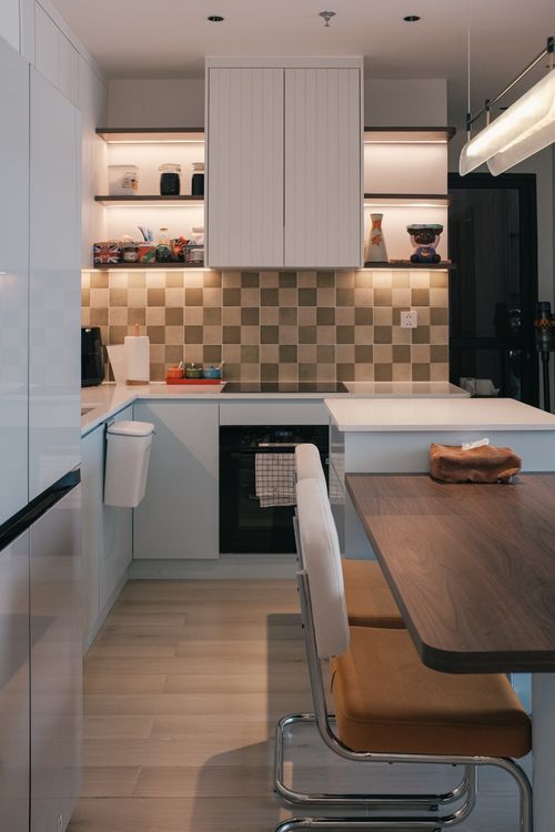 Free Sleek, modern kitchen with minimalist design and warm lighting for a cozy atmosphere. Stock Photo