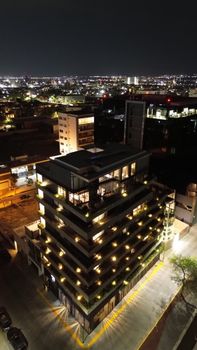 A stunning aerial night view of a lit modern building in Aguascalientes, Mexico.
