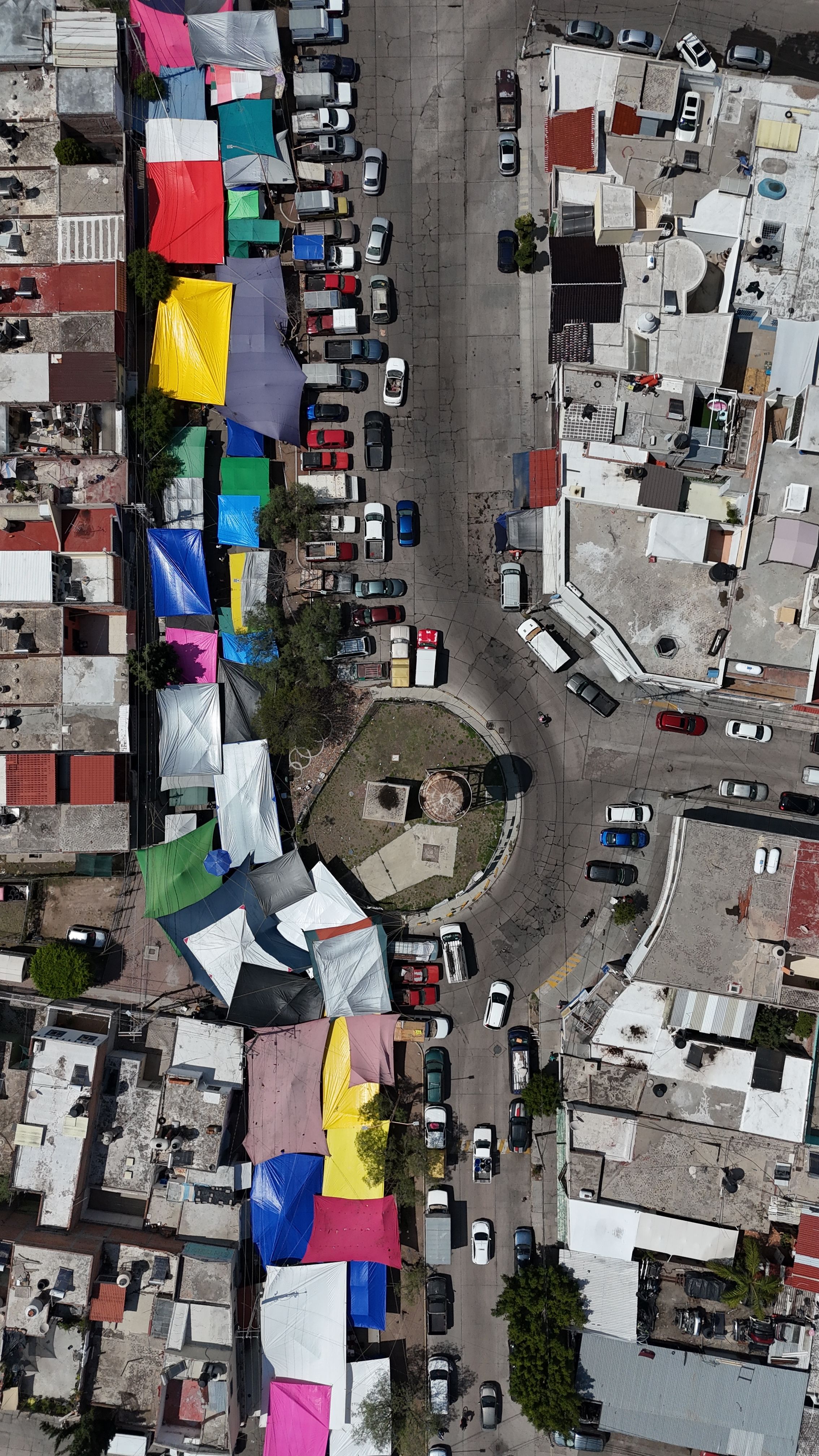 Vibrant aerial view of a colorful street market surrounded by buildings in Aguascalientes, Mexico.