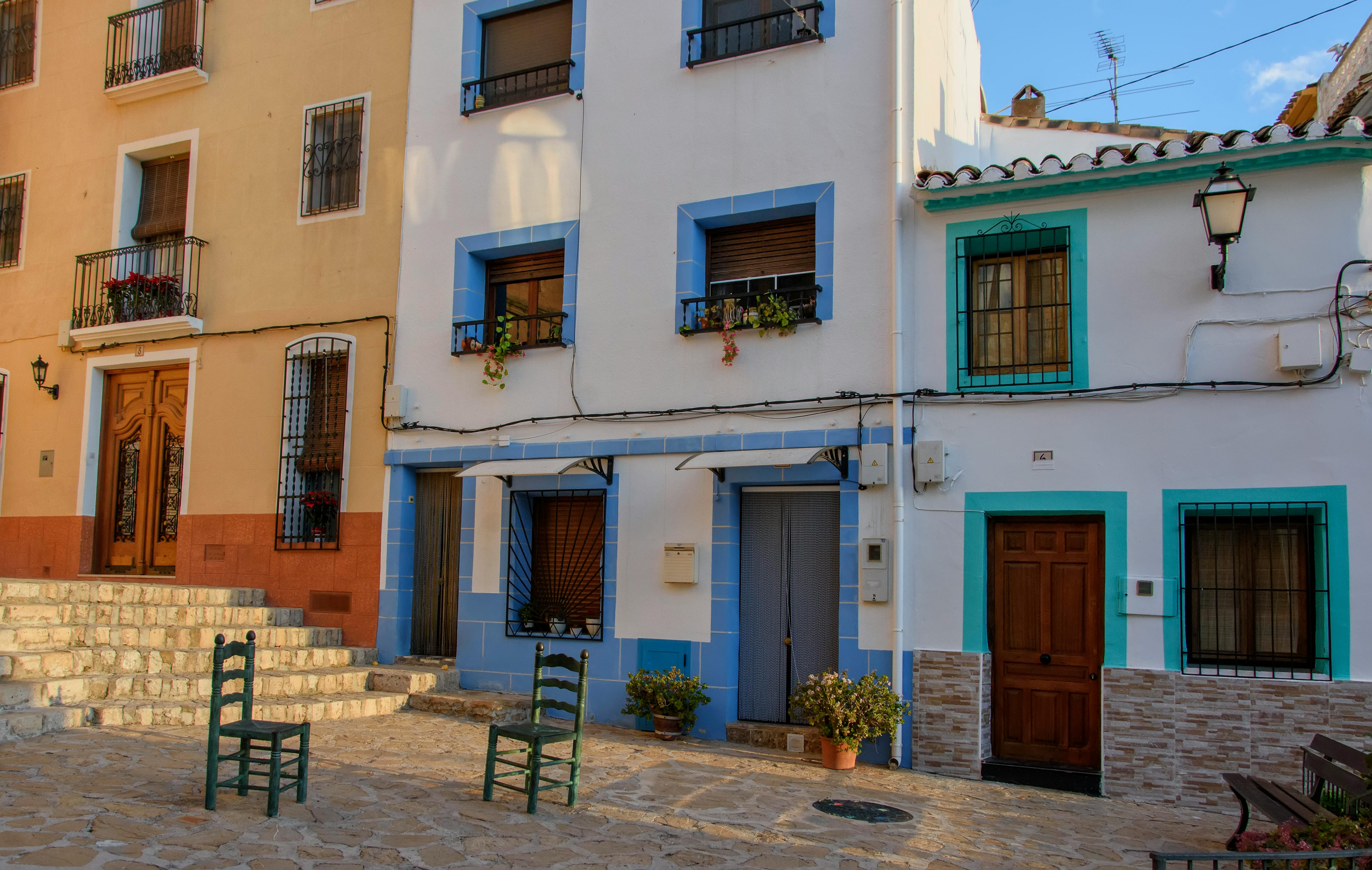 Charming colorful facades of village houses in the sunny town of Finestrat, Spain.