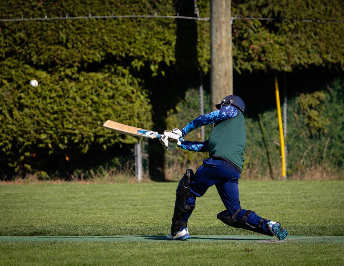 Cricket batsman playing a shot in a Meridian team uniform