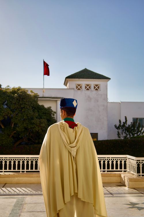 Free Back view of a Moroccan guard in traditional attire at a historic palace in Rabat, Morocco. Stock Photo