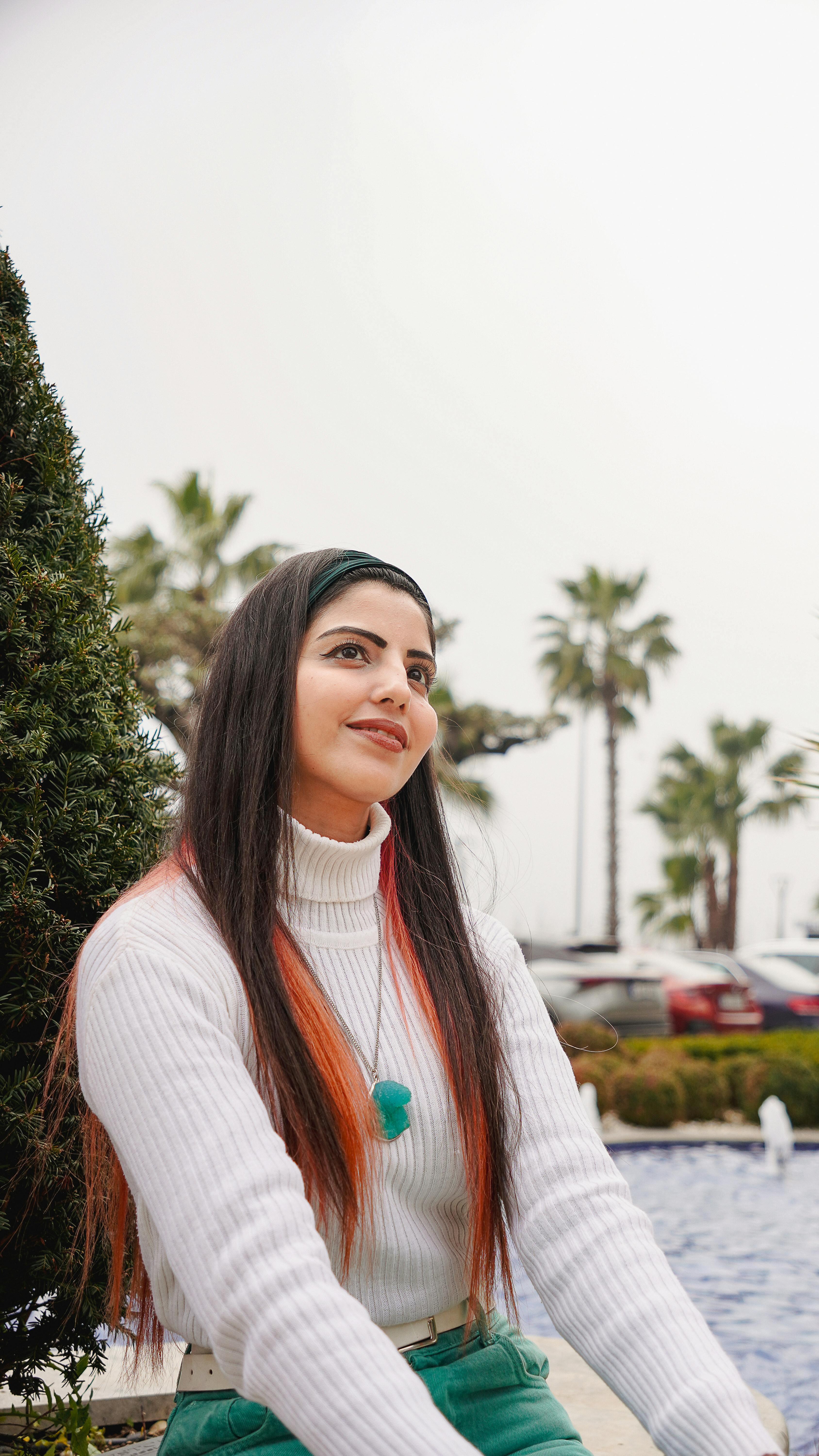 Smiling woman in fashionable attire enjoying a leisurely day in Istanbul's vibrant surroundings.